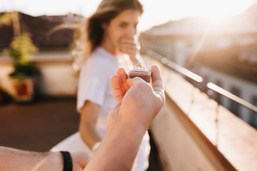 hochzeitsrausch Brautmoden - romantischer Heiratsantrag bei Sonnenuntergang mit Verlobungsring im Fokus