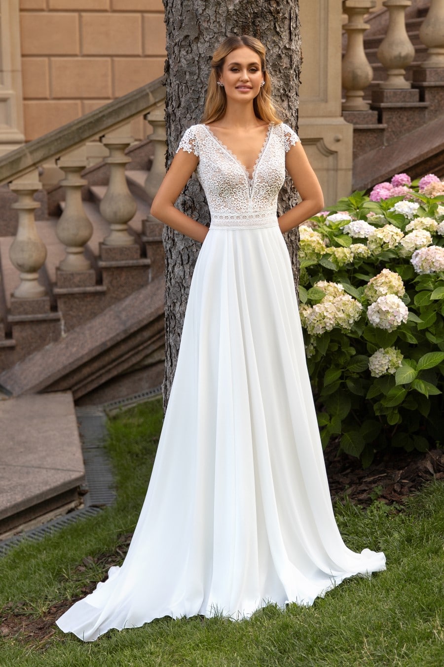 hochzeitsrausch Brautmoden - Elegantes Brautkleid mit Spitzenoberteil und fließendem Rock im Garten-Setting