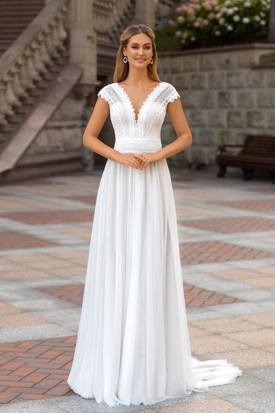 hochzeitsrausch Brautmoden - Elegantes Brautkleid mit Spitzenoberteil und V-Ausschnitt in romantischer Kulisse