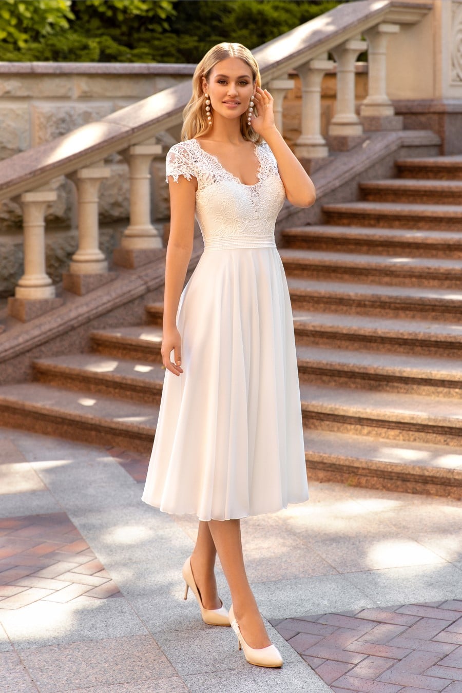 hochzeitsrausch Brautmoden - Elegantes Brautkleid mit Spitzenärmeln und V-Ausschnitt im Garten-Setting