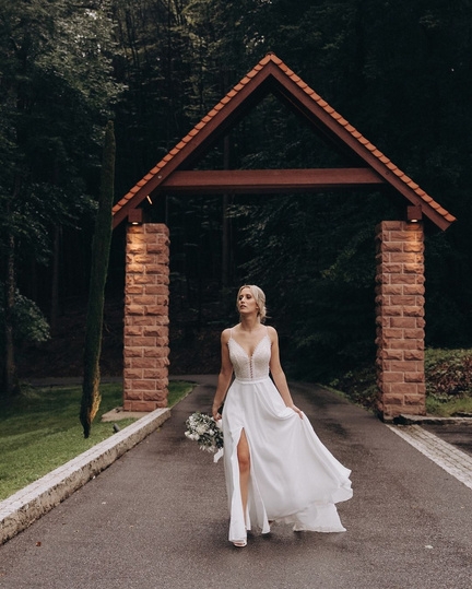 hochzeitsrausch Brautmoden - Elegantes Brautkleid mit Spitzen und Schlitz, romantische Waldkulisse