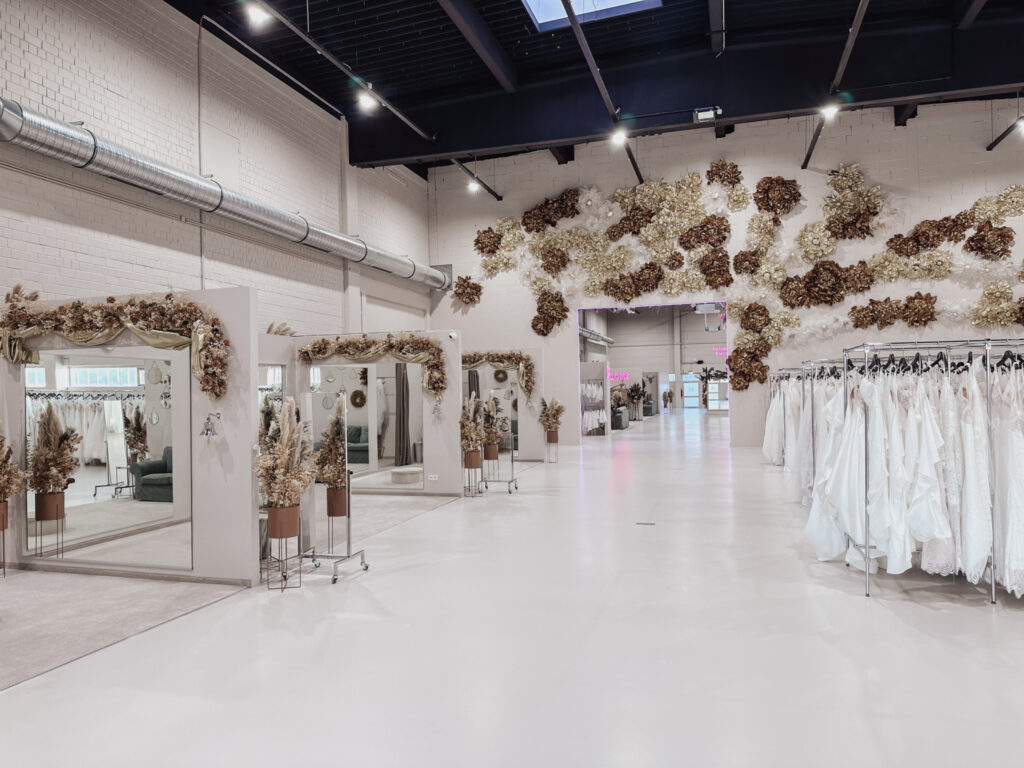hochzeitsrausch Brautmoden - Elegante Brautkleider-Auswahl in stilvollem Showroom mit floraler Dekoration