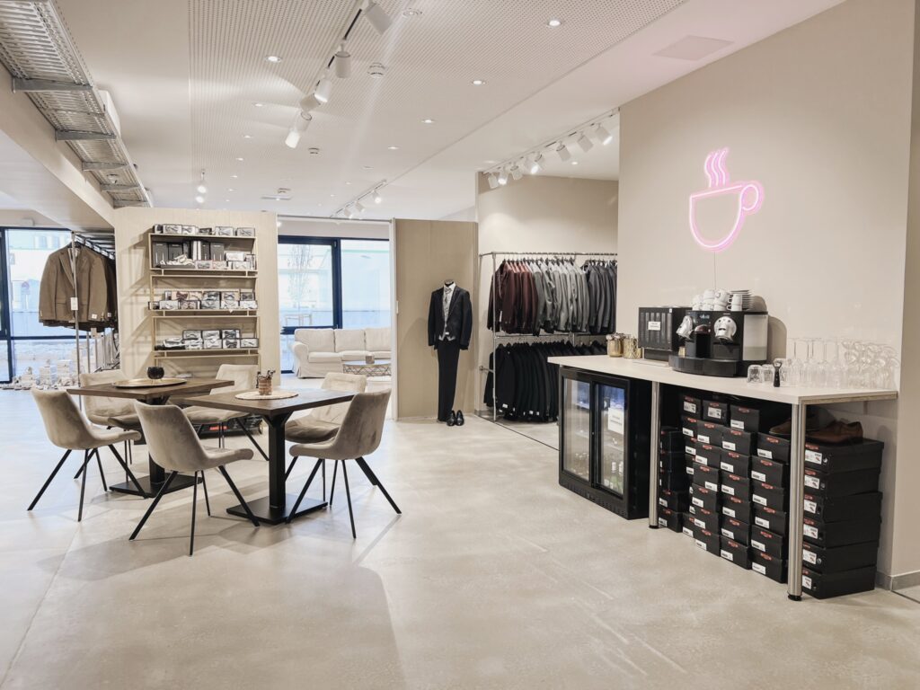 hochzeitsrausch Brautmoden - Eleganter Braeutigam-Anzug im modernen Showroom mit stilvoller Einrichtung und Kaffee-Ecke