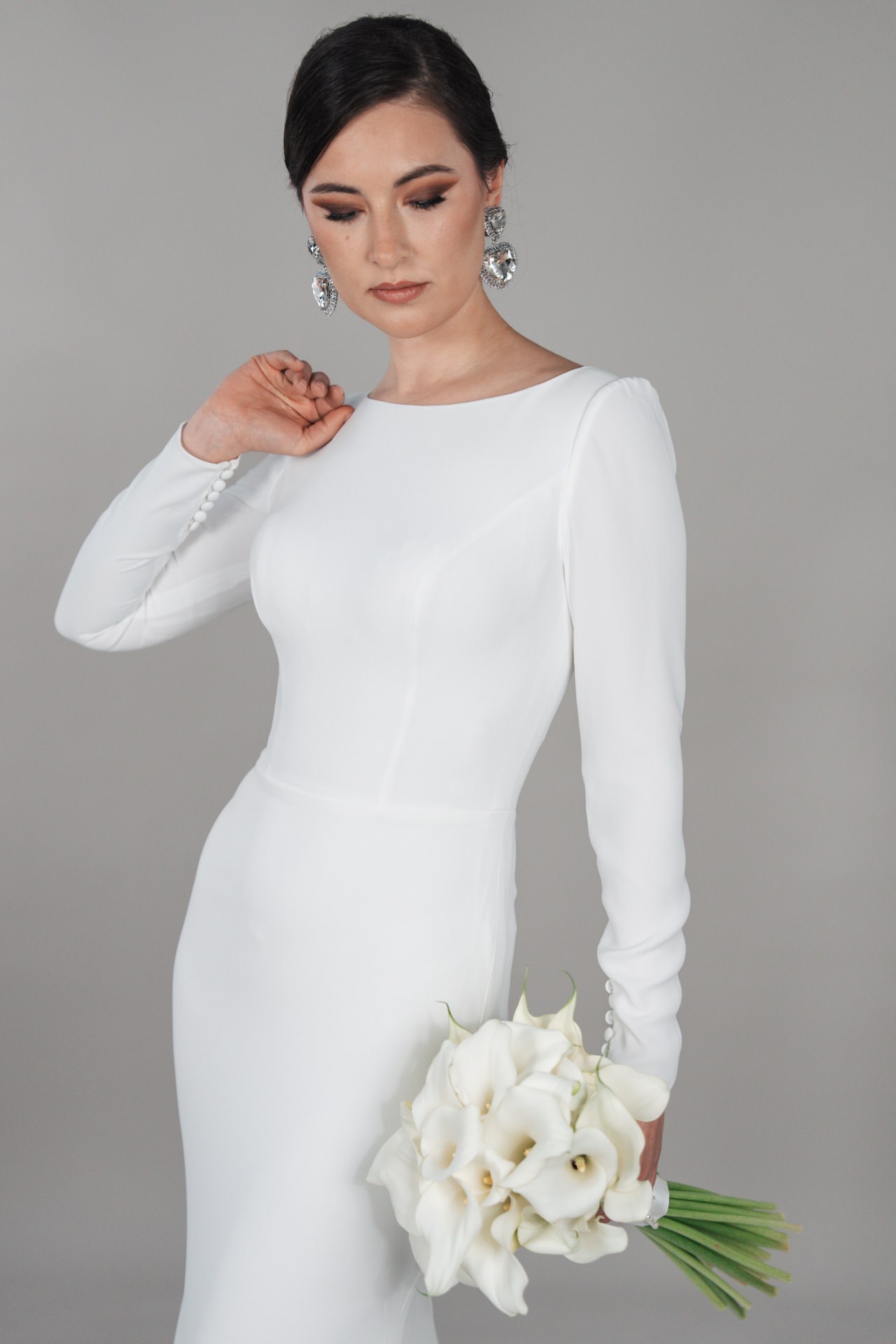 hochzeitsrausch Brautmoden - Elegantes hochgeschlossenes Brautkleid mit langen Ärmeln und Blumenstrauß