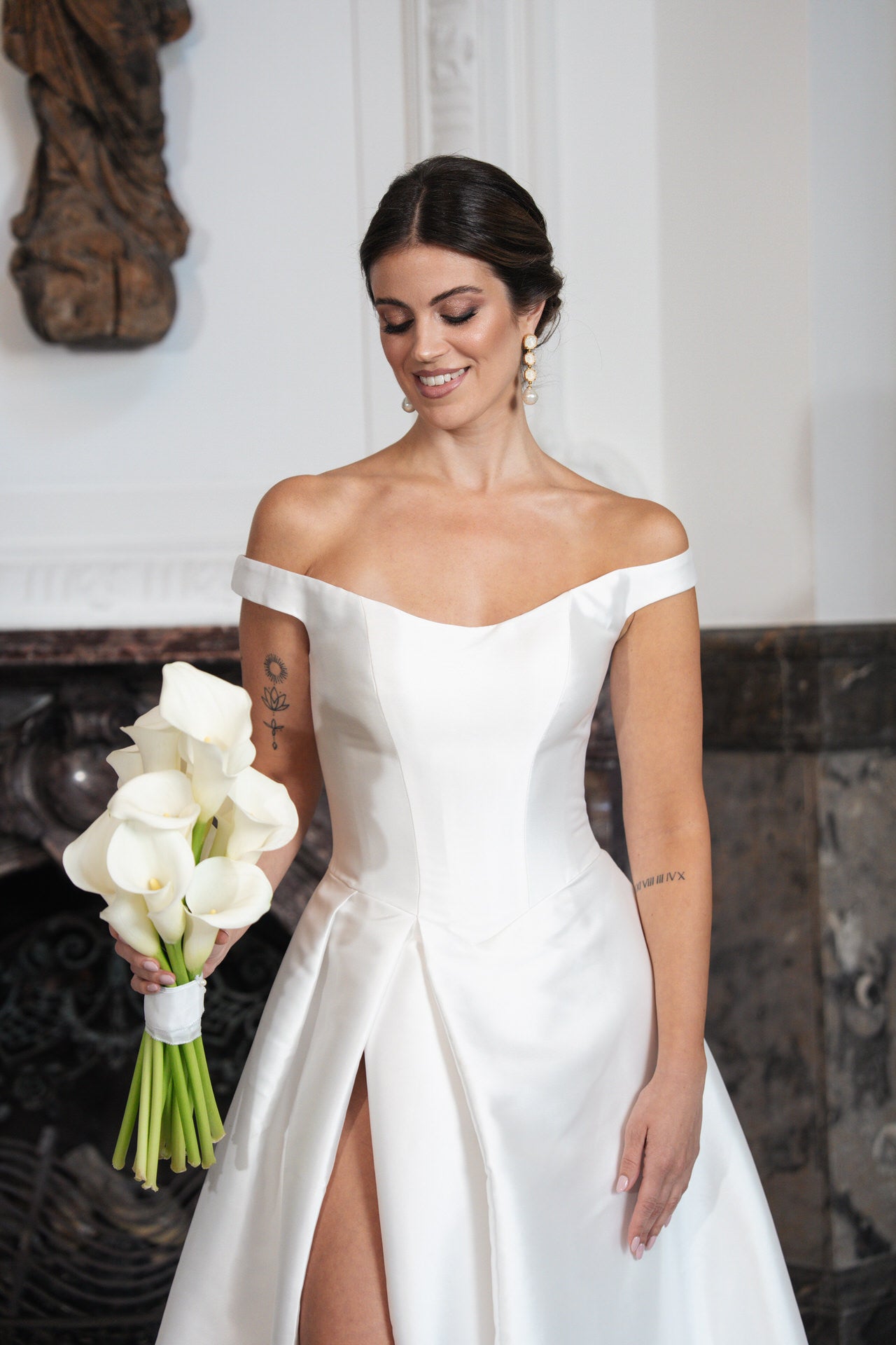 hochzeitsrausch Brautmoden - Elegantes Brautkleid mit Off-Shoulder-Design und hohem Schlitz, Brautstrauß aus Calla-Lilien