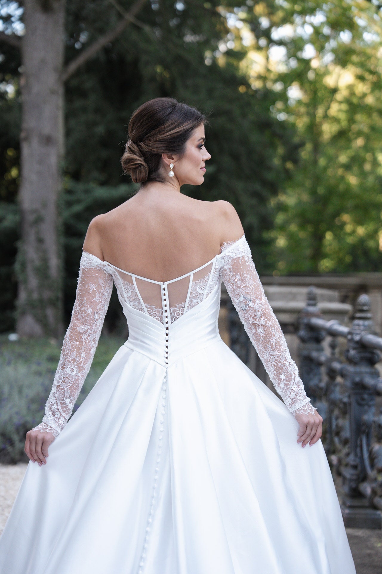 hochzeitsrausch Brautmoden - Elegantes Brautkleid mit Spitzenärmeln und Knopfleiste im Garten-Setting