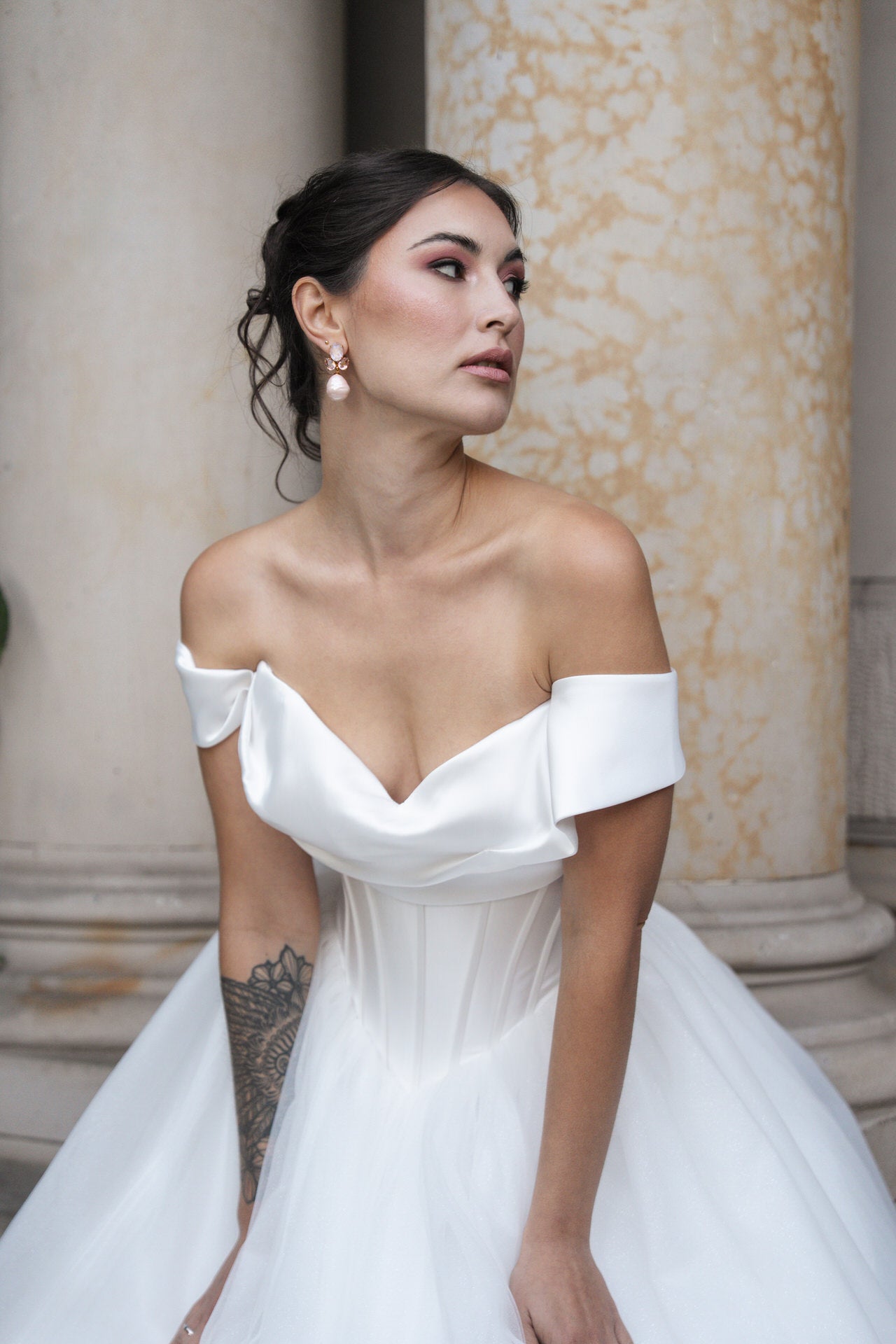 hochzeitsrausch Brautmoden - Elegantes Brautkleid mit schulterfreiem Satinoberteil und Tüllrock vor klassischer Kulisse