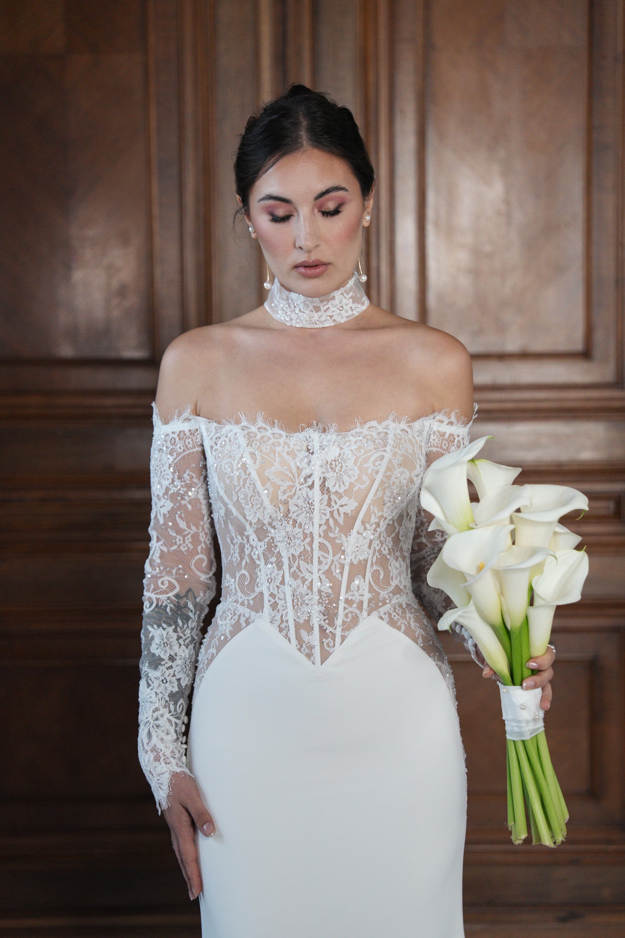 hochzeitsrausch Brautmoden - Elegantes Brautkleid mit Spitzenoberteil und schulterfreiem Design, Calla-Lilien in der Hand