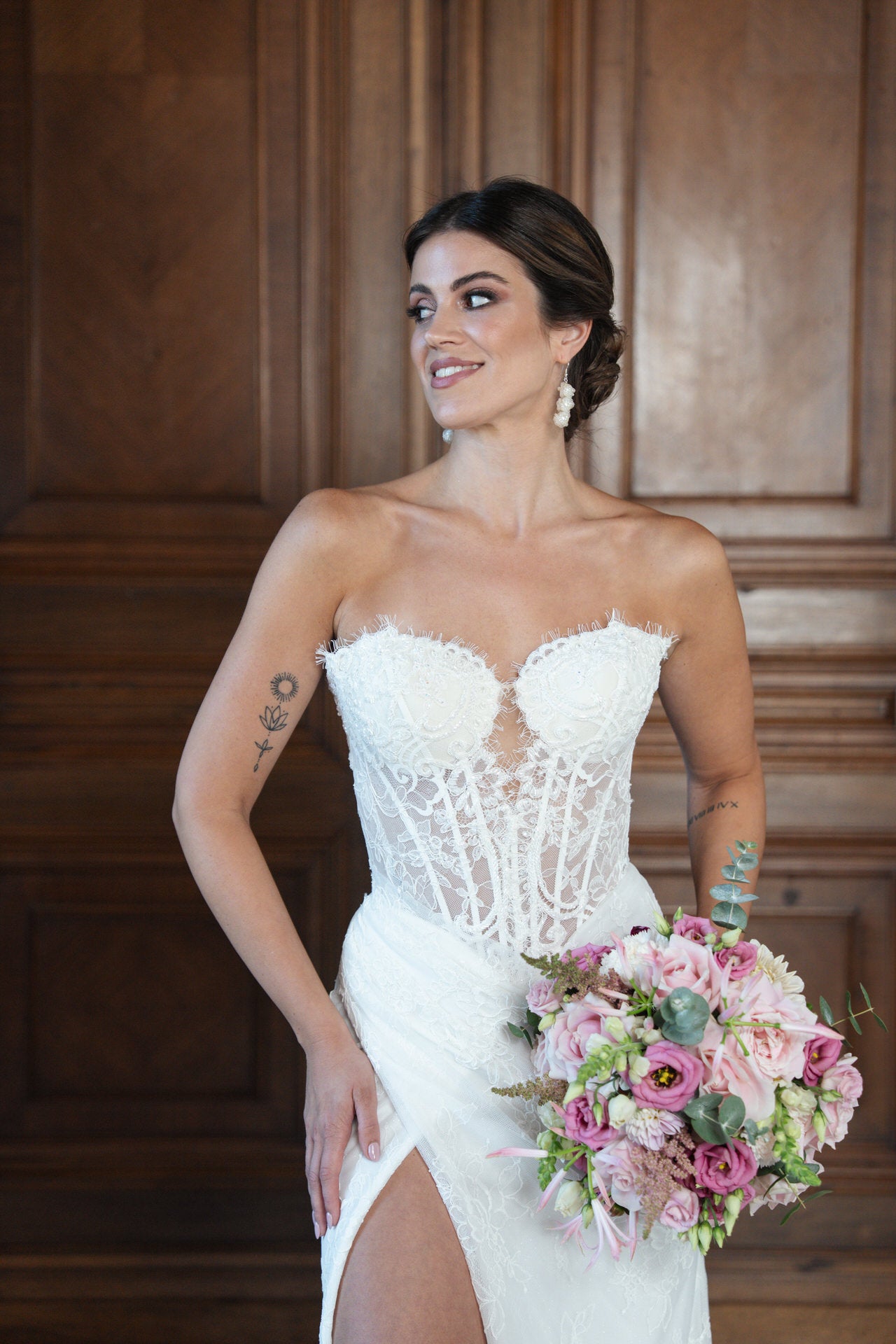 hochzeitsrausch Brautmoden - Elegantes Brautkleid mit Spitzenkorsage und Blumenstrauß in edlem Ambiente
