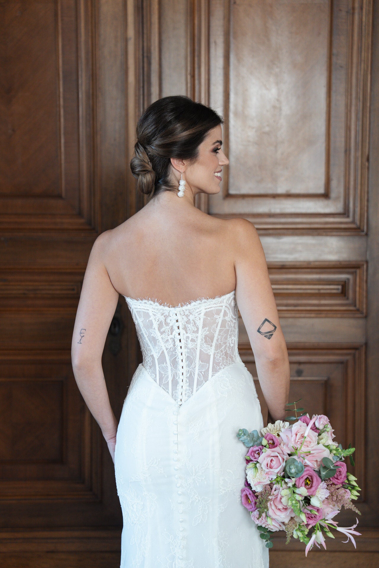 hochzeitsrausch Brautmoden - Brautkleid mit Spitzenkorsett und Blumenstrauß in elegantem Ambiente