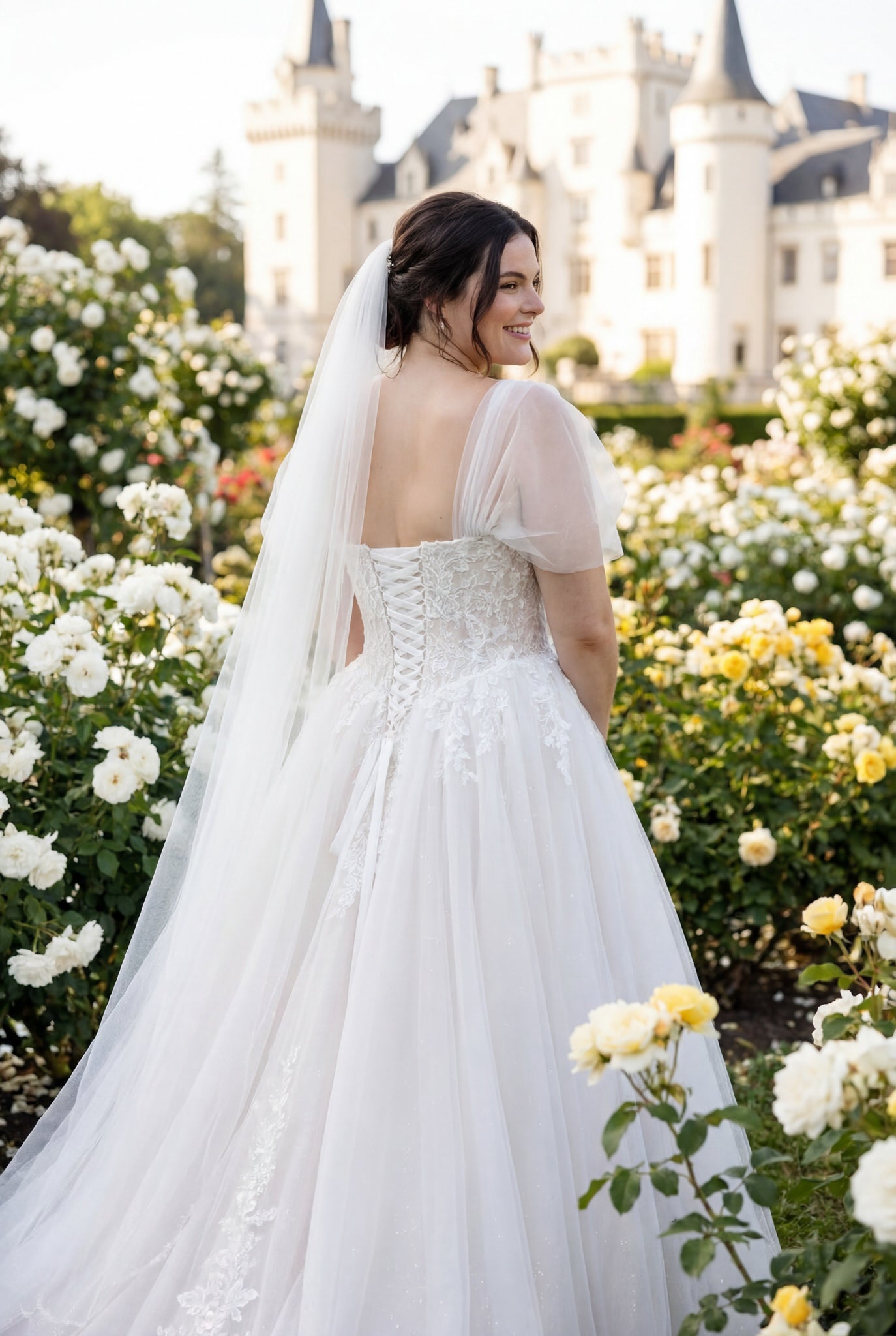 hochzeitsrausch Brautmoden - Brautkleid mit Spitzenrücken und Tüllrock in romantischem Rosengarten vor Schlosskulisse